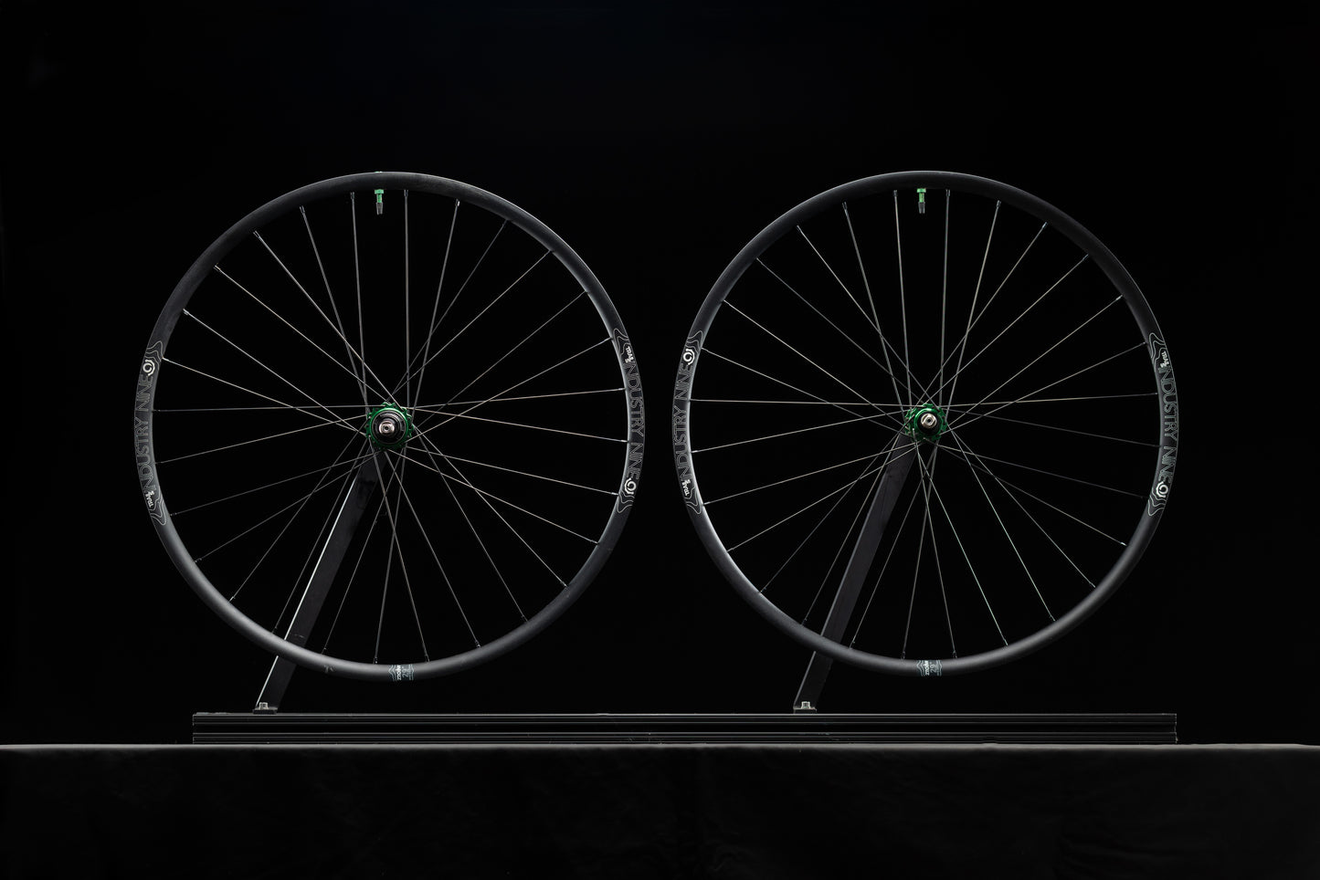 Two bicycle wheels on a black background