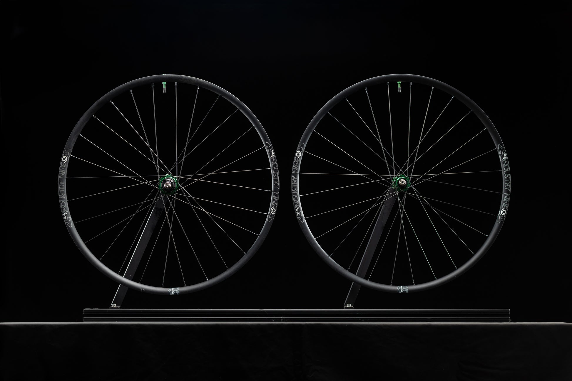 Two bicycle wheels on a black background