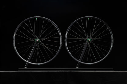 Two bicycle wheels on a black background
