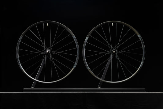 Two bicycle wheels on a black background