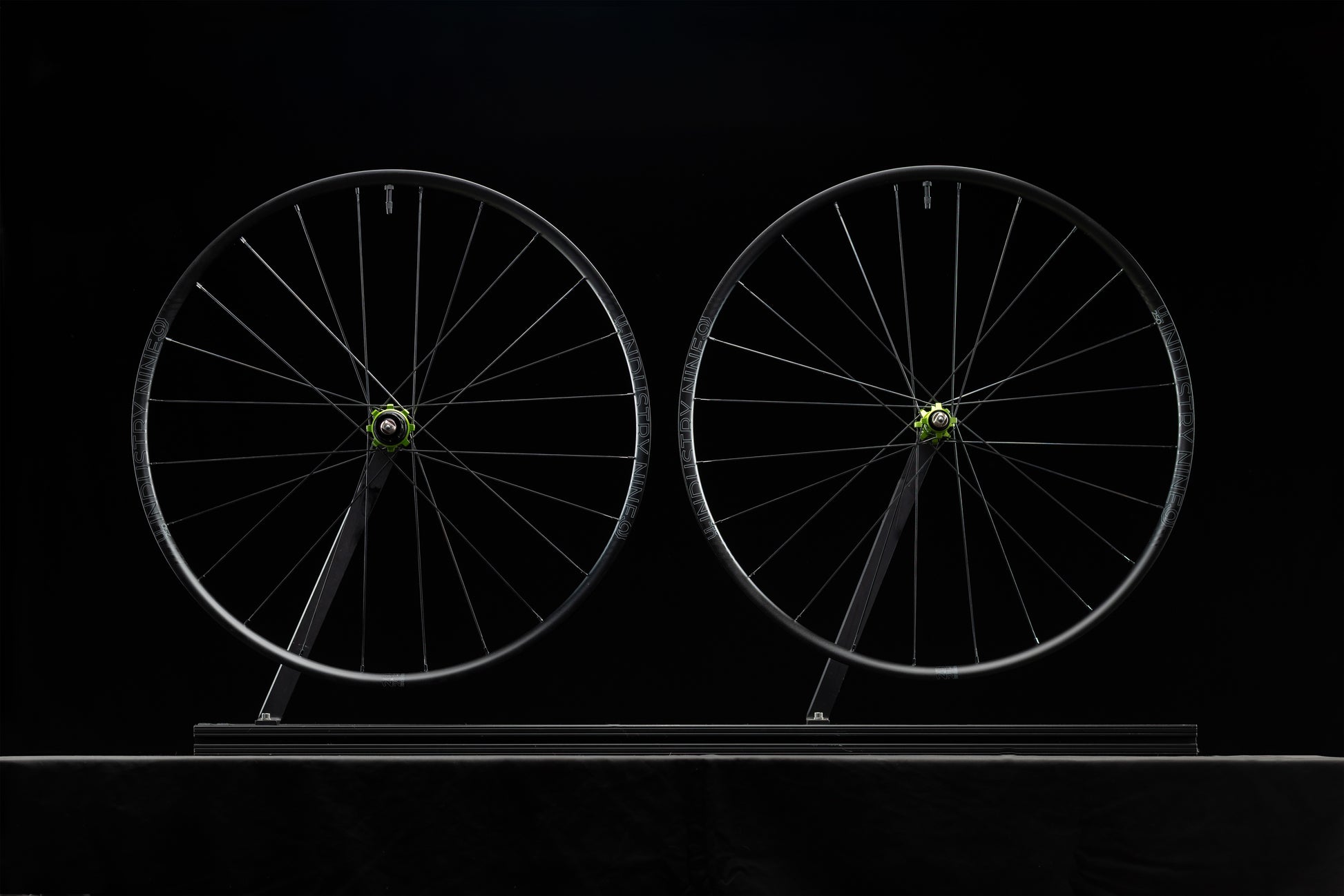 Two bicycle wheels on a black background