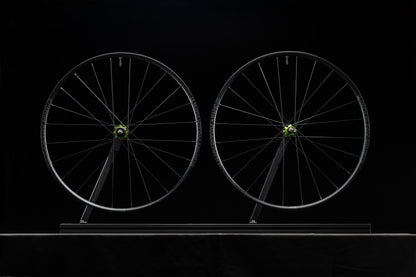 Two bicycle wheels on a black background