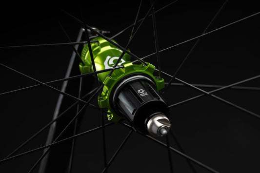 Close-up of a lime bicycle hub with spokes against a black background